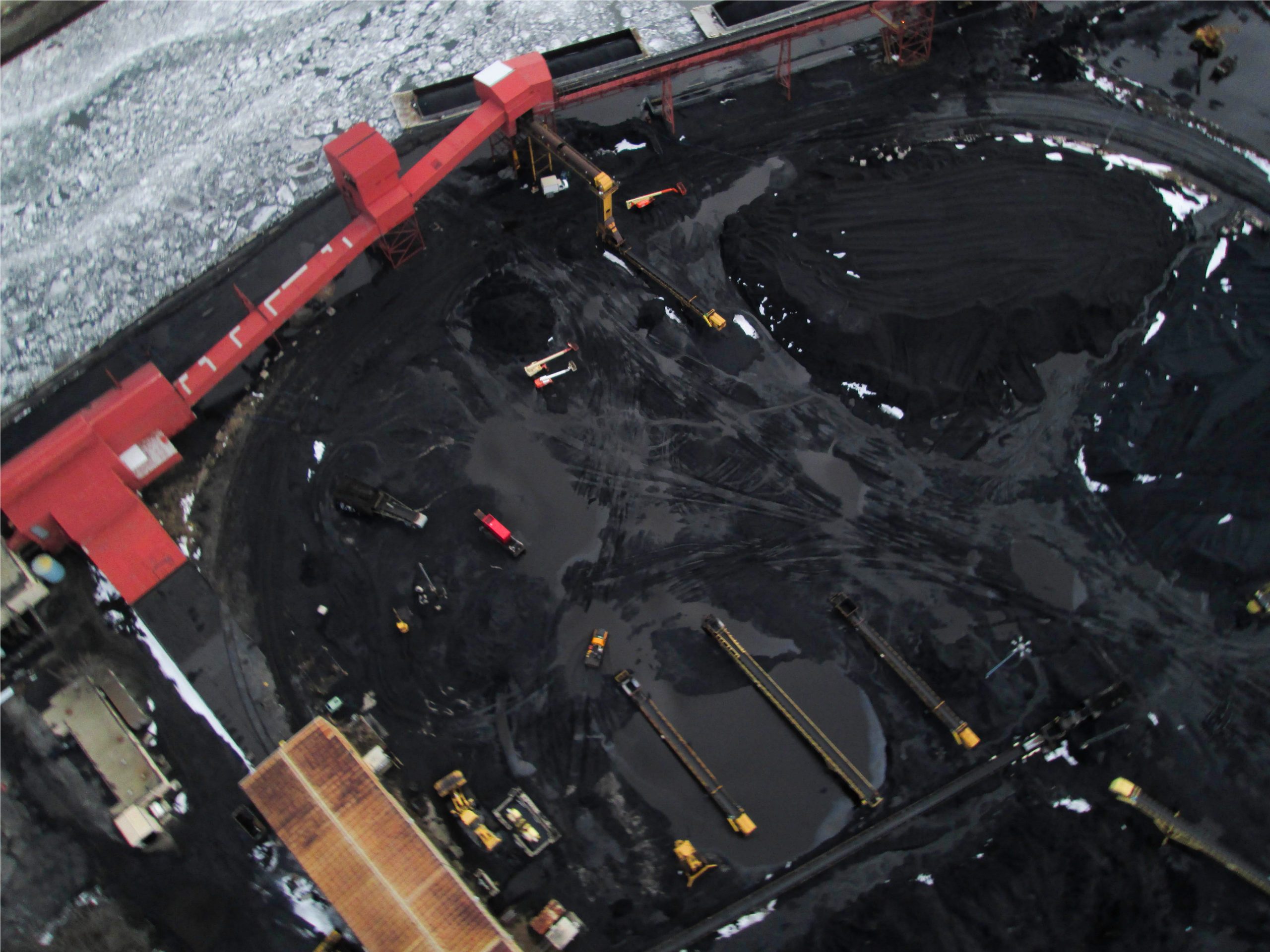 KCBX, a subsidiary of Koch industries, stores open piles of pet coke at it's 90 acre terminal along the Calumet River in Chicago's Southeast Side. (Credit Public Lab)