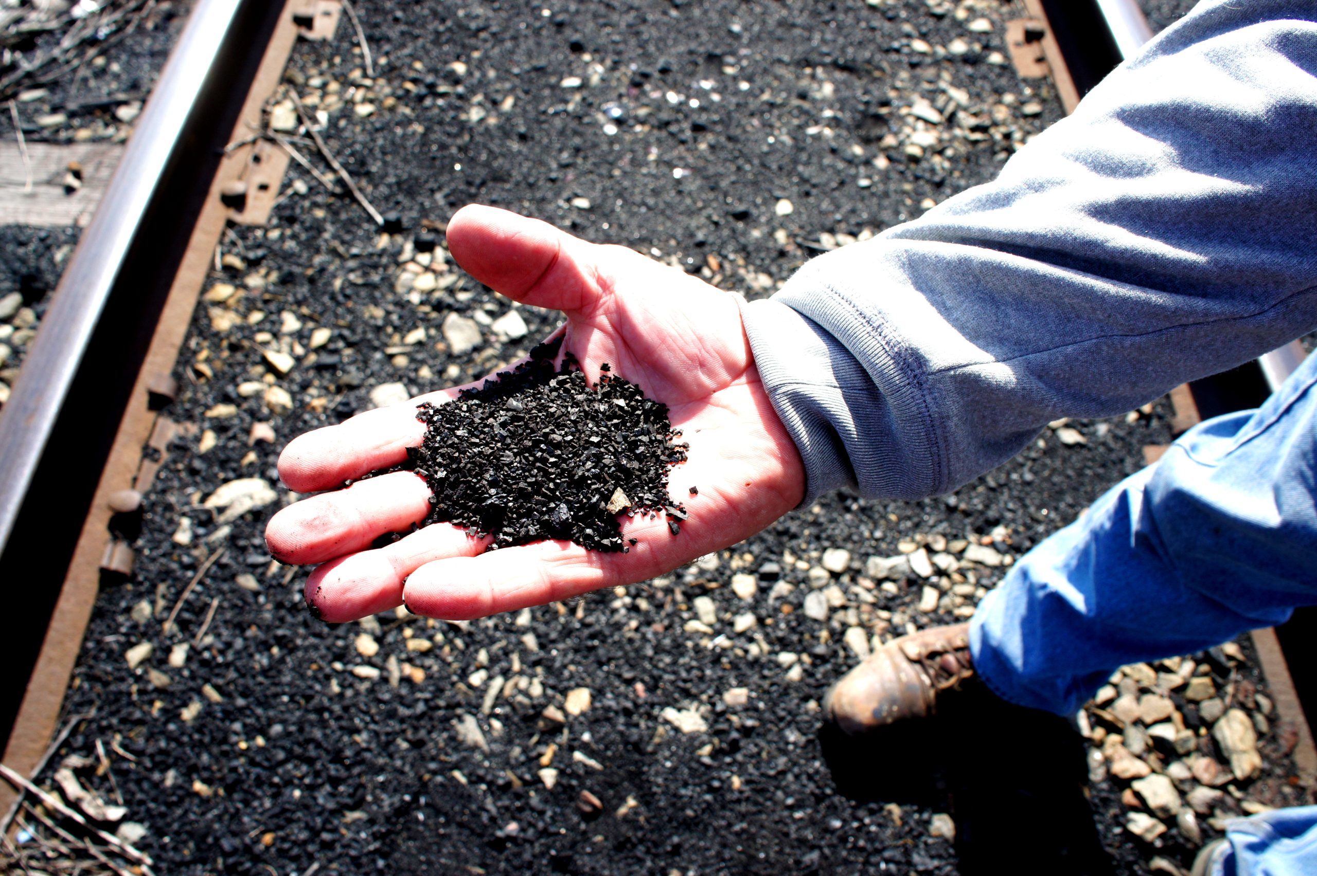 Pet coke covers the railroad tracks that are a border between the backyards of Southeast Side, Chicago families and KCBX's terminal.