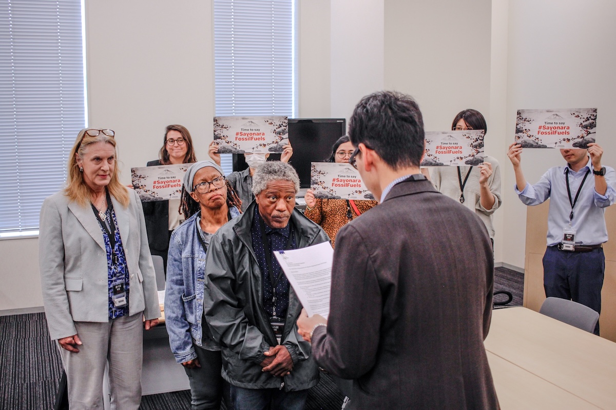 Texas community leader Manning Rollerson Jr. delivers a complaint to a representative of the Japan Bank for International Cooperation, a major financier of U.S. LNG projects.
