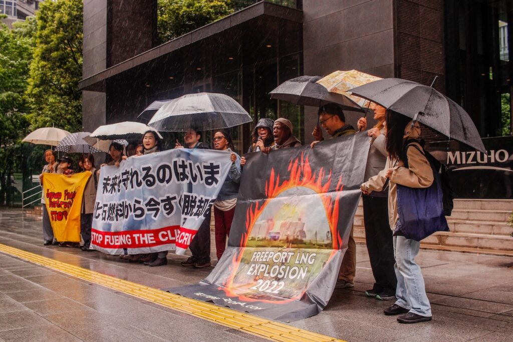 A protest in front of megabanks' headquarters in Tokyo. Freeport community leaders and members of Japanese environmental groups hold up banners about the 2022 Freeport LNG explosion and the need for Japan to stop financing LNG.