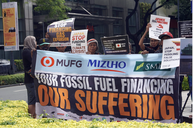 A group of people holding a banner that says, "MUFG, Mizhuo, and SMBC: Your fossil fuel financing, our suffering."
